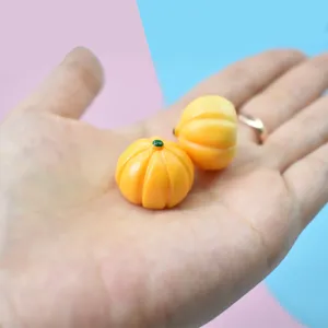Gros plan de citrouilles miniatures en résine pour le bricolage tenues à la main