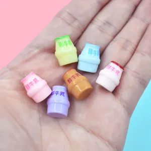 Primo piano di mini bottiglie di latte colorate in resina su palmo per decorazioni fai-da-te.