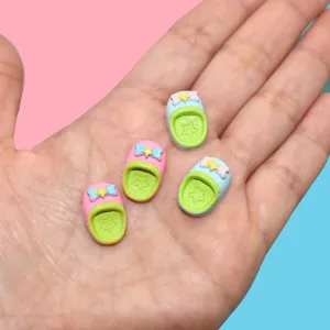 Macro view of miniature resin slipper accessories for DIY phone cases held in palm