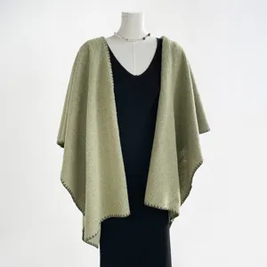 Vista detallada del elegante chal capa de punto verde oliva para mujer, prenda otoñal acogedora.