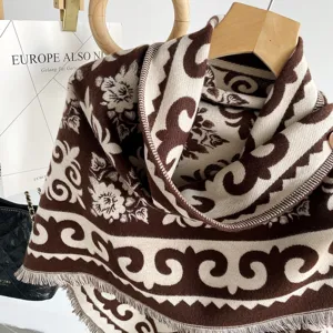 Detailed shot of thick brown jacquard cashmere-feel shawl scarf with fringe hemline.