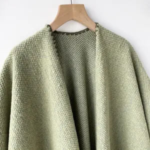Vista detallada de cárdigan chal de punto verde para mujer, prenda de moda otoñal casual.
