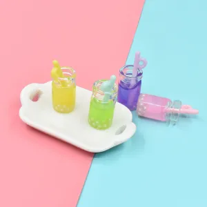 Detailaufnahme bunter Miniatur-Bubble-Tea-Flaschen auf einem kleinen weißen Tablett