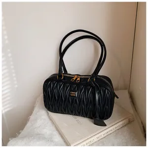 Black quilted shoulder bag detail, stylish pleated design, soft leather texture, gold hardware.
