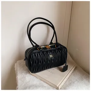 Detailed view of the black pleated shoulder pillow bag with soft texture and gold hardware.