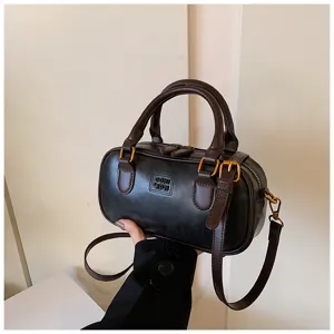 Retro casual bowling handbag with dual top handles, dark PU leather and chic gold hardware.