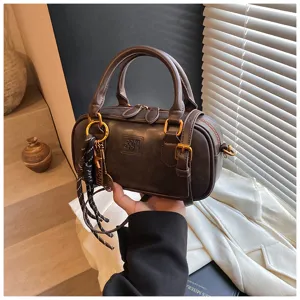 Close-up of retro brown bowling handbag, detailed metal hardware, stylish handheld design.