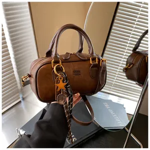Retro brown leather bowling bag detail view, showing exquisite metal hardware and stylish charms.