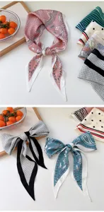 Close-up of stylish printed silk scarves with polka dots and paisley for versatile wear.