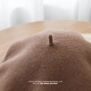 Primer plano de la boina de lana que muestra textura delicada y detalle superior, estilo marrón.