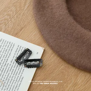 Vista detallada de la boina de lana marrón que muestra su textura suave en la mesa de madera.
