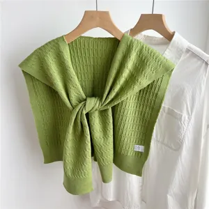 Detailed shot of green knitted fake collar shawl over white shirt, stylish shoulder wrap.