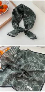 Detailed view of dark green paisley cotton small square scarf showing fabric texture.