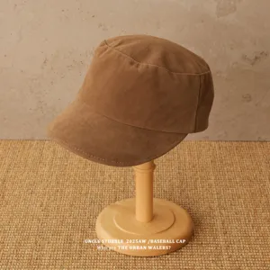 Detailed close-up shot of the brown suede flat top cap, highlighting soft texture and fine stitching.