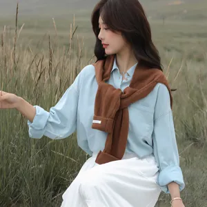 Koreanischer Strickschal kombiniert mit blauem Hemd, elegante Herbst-Modeedetailaufnahme.