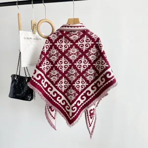 Warm knitted shawl cape for women, vintage jacquard retro design with fringe, winter style.