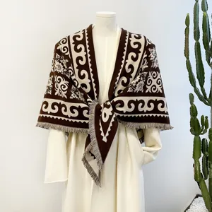 Detailed view of brown and white jacquard patterned winter shawl scarf with stylish fringe edges.