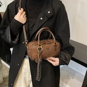 Vintage brown bowling shoulder bag for women, retro casual handbag with chic tassel pendant.