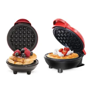 Vista di dettaglio in primo piano della mini piastra per waffle elettrica rossa rotonda e dolci.