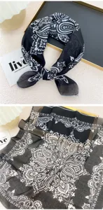 Detailed view of black and white paisley square scarf, soft fabric close-up pattern display.