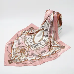 Detail shot of pink silk square scarf featuring elegant chain and belt print patterns.