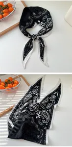 Detailed view of a chic black and white printed silk scarf with elegant paisley and motifs.