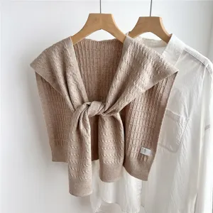 Detail shot of a cozy beige knit fake collar shawl, showing the delicate textured knit weave.