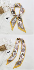 Vue rapprochée détaillée d'un long foulard en soie étroit avec imprimé grue et lotus.