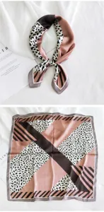 Detalle en primer plano del pañuelo cuadrado elegante de seda con estampado de leopardo geométrico.