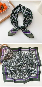 Detailed view of the dark green floral square scarf showing soft fabric and geometric border.