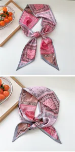 Vista detallada del pañuelo de seda con estampado paisley rosa y gris, muy elegante.