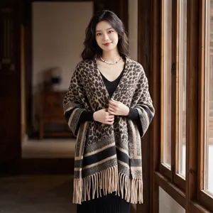 Elegant leopard print knitted shawl with fringe, detailed view of winter fashion cape.