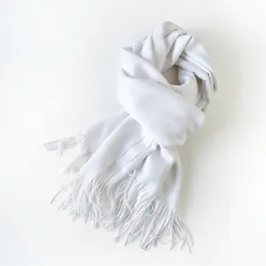 Detailansicht eines weichen, weißen Fransienschals mit eleganter Textur und gemütlicher Wärme.