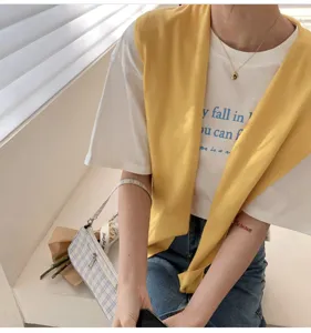 Detailed close-up of the stylish knitted shoulder shawl paired with casual white t.