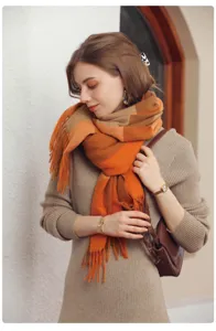 Gros plan sur les détails de l'écharpe à franges à carreaux orange et texture douce d'automne.