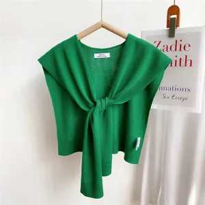 Green knitted shawl top detail view, elegant front tie wrap design, lightweight summer layer.