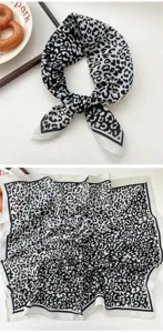 Closeup detail view of black and white leopard print square scarf neckerchief, soft satin.
