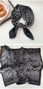 Close-up of black and white leopard print square scarf showing detailed fabric texture.