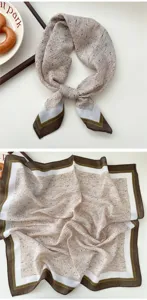 Detail shot of the stylish beige speckled small square scarf featuring a classic brown and white border.