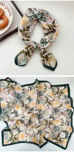 Detailed view of floral silk square scarf with elegant leaf print and green border.