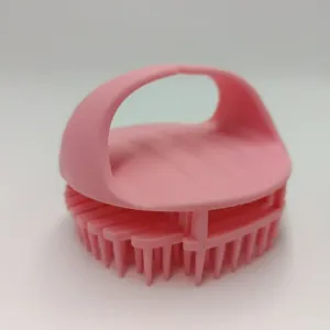 Pink silicone scalp massage brush and shampoo comb for daily hair care and relaxing bath.