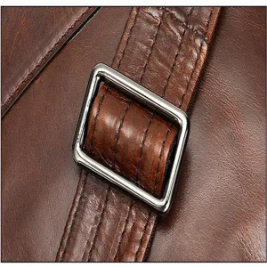 Close-up detail van vintage bruine echt lederen reistas riem met metalen gesp en stiksels.