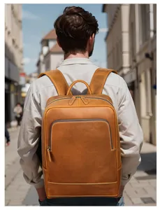 Close-up scene of a stylish brown leather backpack worn outdoors, showing large capacity and design.
