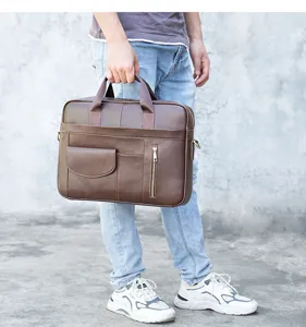 Detail shot of brown leather business briefcase with dual handles and front pockets.