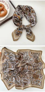 Detailed view of brown and white paisley pattern silk scarf, elegant neckerchief style close up.