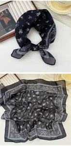 Close-up detail of black cotton linen floral square scarf, elegant paisley border design.