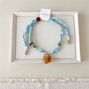 Blauwe bloemige zijden lint halsketting met kleurrijke kralen en hanger voor stijlvolle dames.