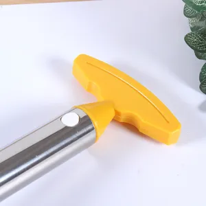 Stainless steel pineapple corer detail shot, yellow handle, kitchen tool close up view.