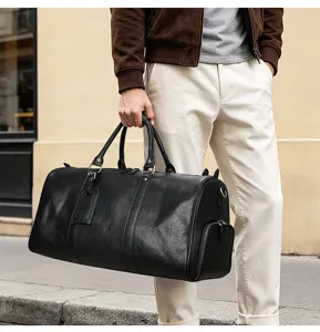 Vue de détail du sac de voyage en cuir noir avec poche latérale et poignées.