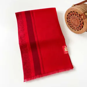 Detailed view of the red winter scarf featuring stylish stripes and delicate woven edge patterns.